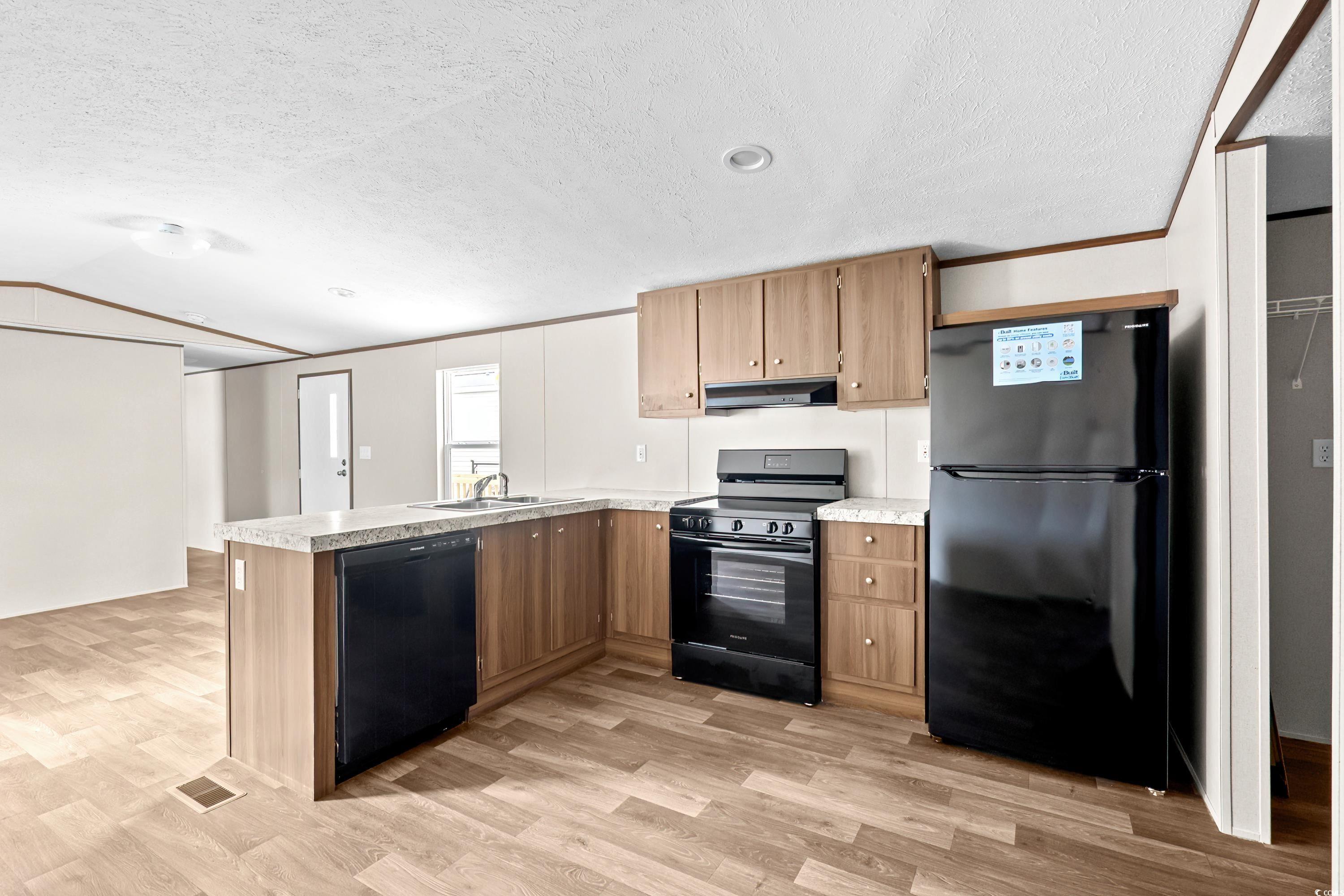 540 Key Largo Avenue Murrells Inlet, SC 29576 - Photo 11 of 34 Kitchen with sink, a textured ceiling, light wood-