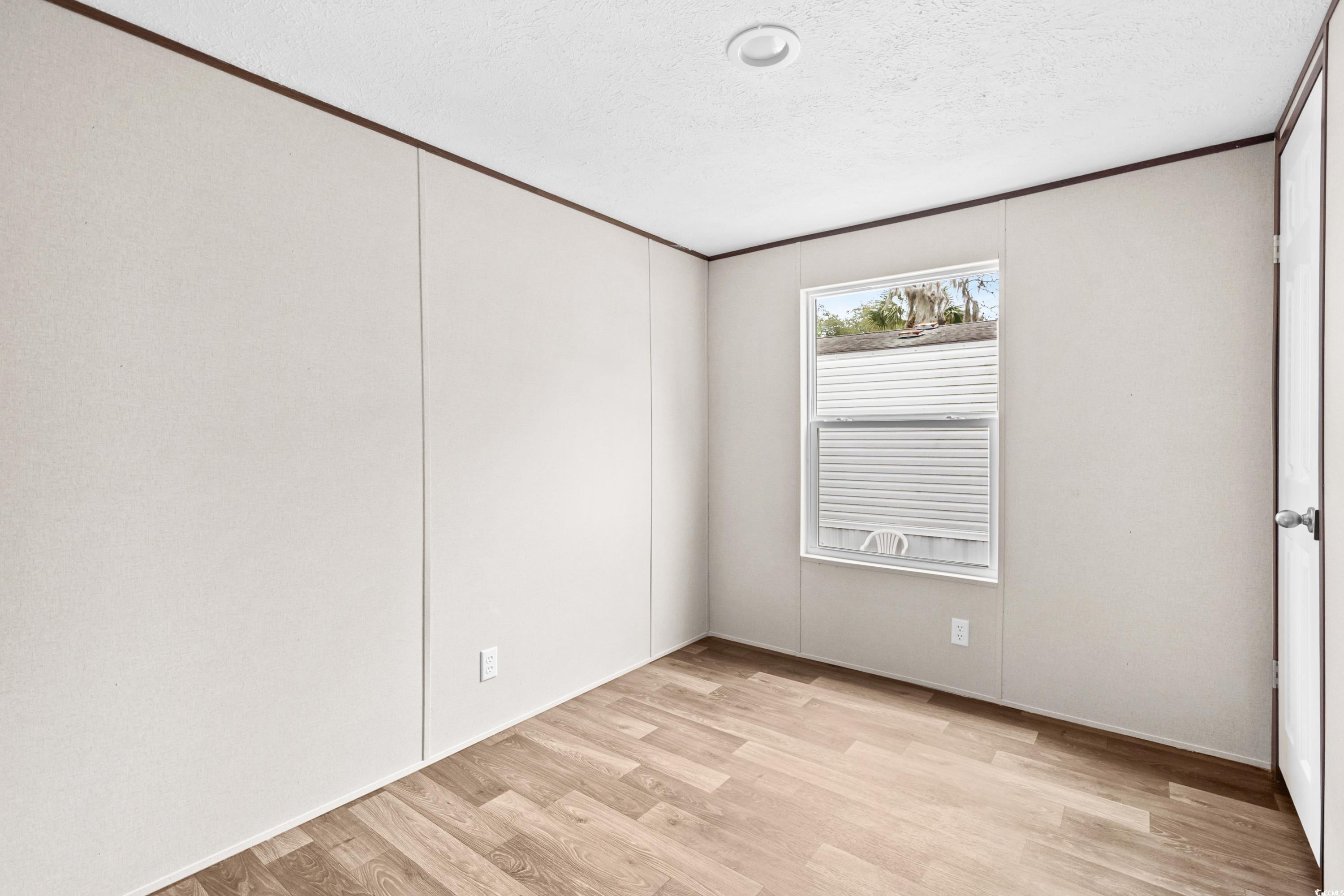 540 Key Largo Avenue Murrells Inlet, SC 29576 - Photo 17 of 34 Empty room with crown molding, light hardwood / wo