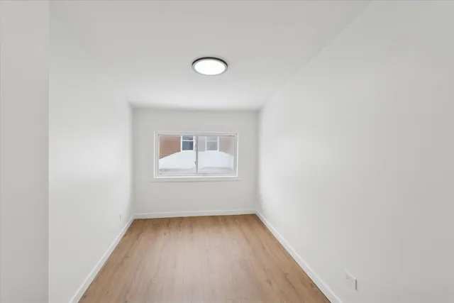 a view of a room with wooden floor and window