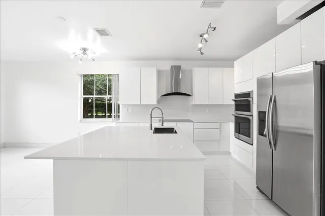 a kitchen with stainless steel appliances a refrigerator sink and cabinets