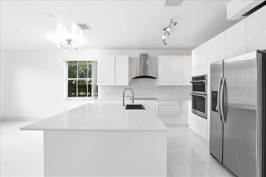 3802 Southwest 165th Terrace Miramar, FL 33027 - Photo 4 of 49 a kitchen with stainless steel appliances a refrigerator sink and cabinets
