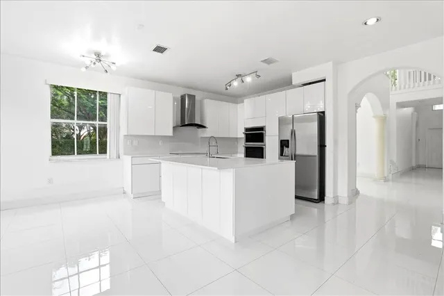 a large white kitchen with cabinets