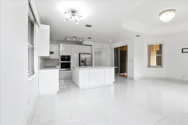a view of kitchen with cabinets and refrigerator