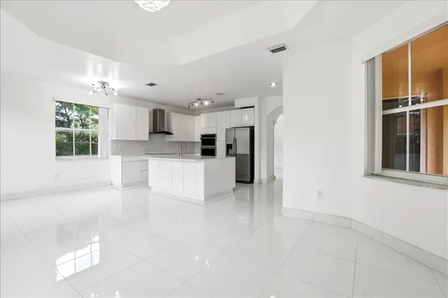 a large white kitchen with white cabinets and stainless steel appliances