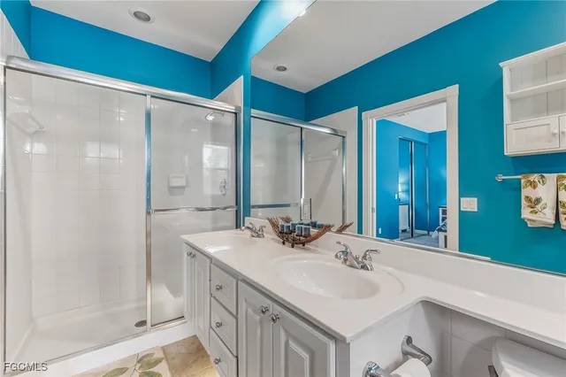 a bathroom with a double vanity sink mirror and shower
