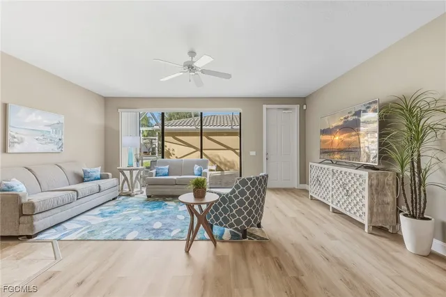 a living room with furniture floor to ceiling window and wooden floor