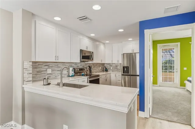 a kitchen with stainless steel appliances a refrigerator sink and microwave