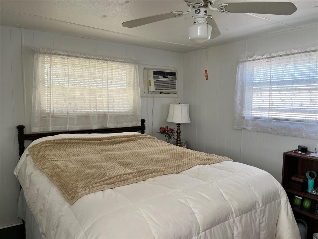 7254 Mt Fairfield Road Northeast, Unit 531 St. Petersburg, FL 33702 - Photo 9 of 19 a bedroom with a bed and a chandelier