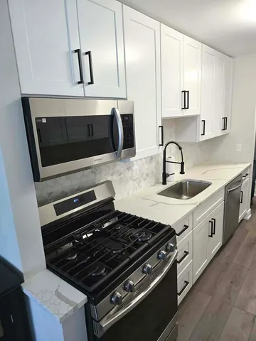 a kitchen with stainless steel appliances a stove a sink and a microwave
