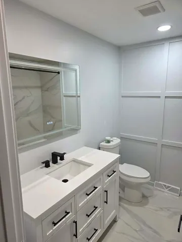 a bathroom with a sink a toilet and shower