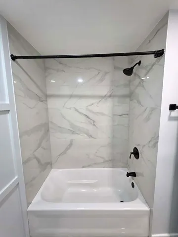 a bathroom with a shower and a bath tub