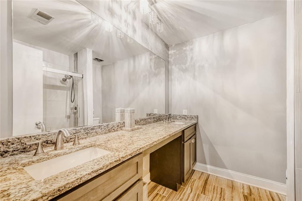 6851 Roswell Road, Unit A5 Atlanta, GA 30328 - Photo 13 of 35 a bathroom with a granite countertop sink and a mirror