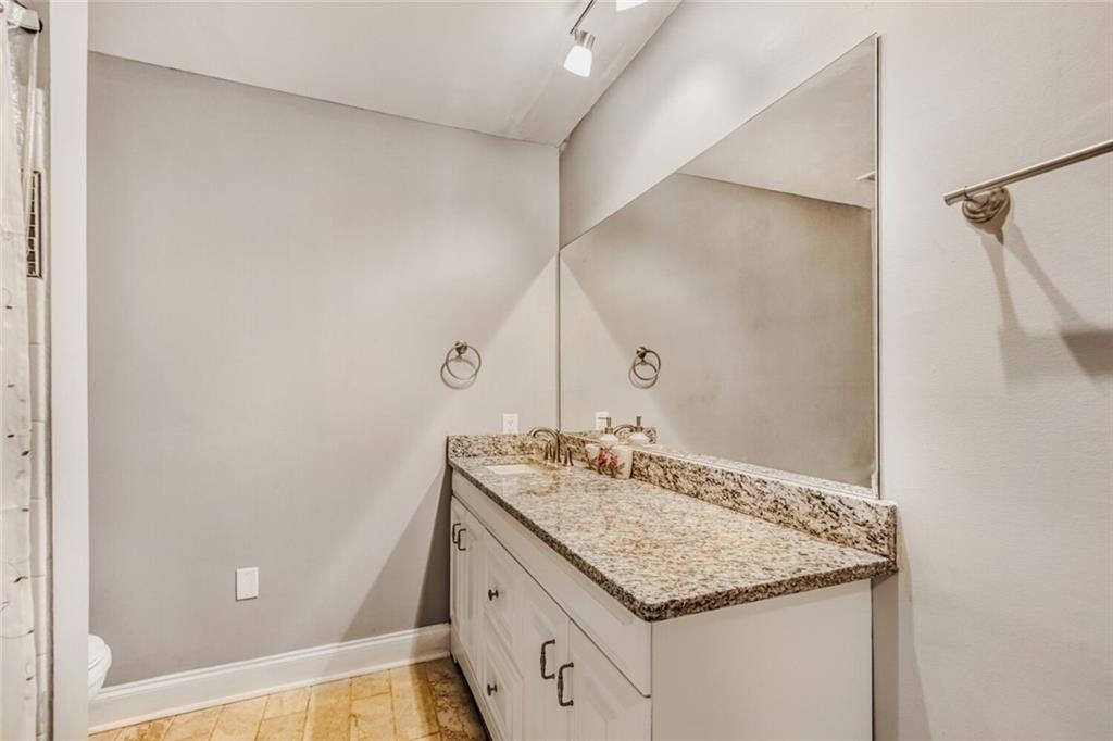 6851 Roswell Road, Unit A5 Atlanta, GA 30328 - Photo 18 of 35 a bathroom with a granite countertop sink and a mirror