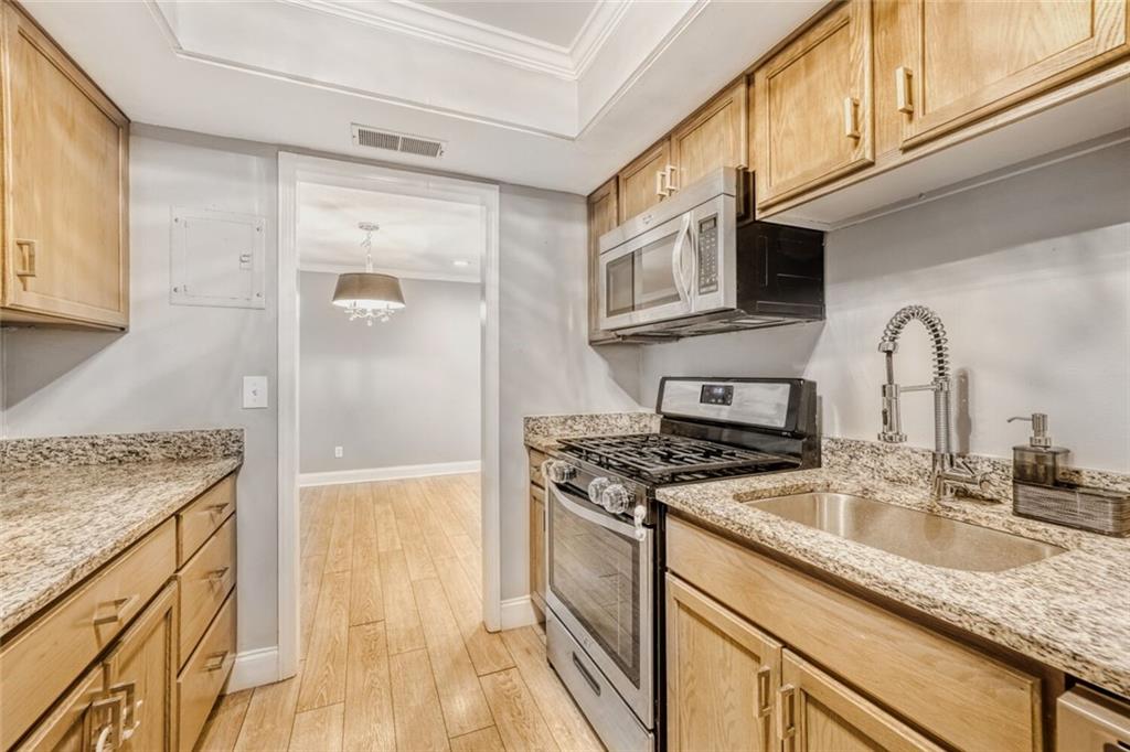 6851 Roswell Road, Unit A5 Atlanta, GA 30328 - Photo 5 of 35 a kitchen with stainless steel appliances granite countertop a sink stove and refrigerator