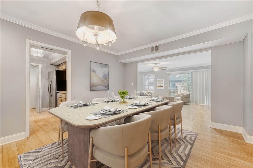 6851 Roswell Road, Unit A5 Atlanta, GA 30328 - Photo 10 of 35 a dining room with wooden floor a chandelier a wooden table and chairs