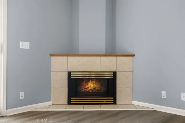 a view of an empty room with window wooden floor and kitchen view