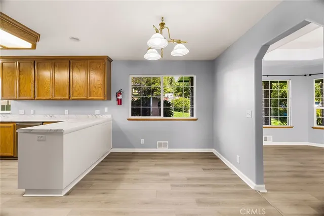a kitchen with granite countertop stainless steel appliances wooden cabinets and a sink