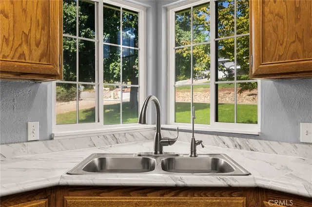 a kitchen with stainless steel appliances granite countertop a sink and cabinets with wooden floor