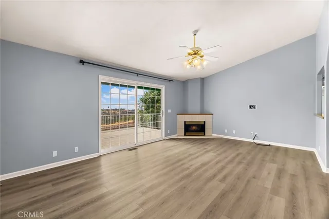 a view of an empty room with a fireplace and a window