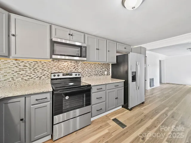 a kitchen with stainless steel appliances a stove sink and refrigerator