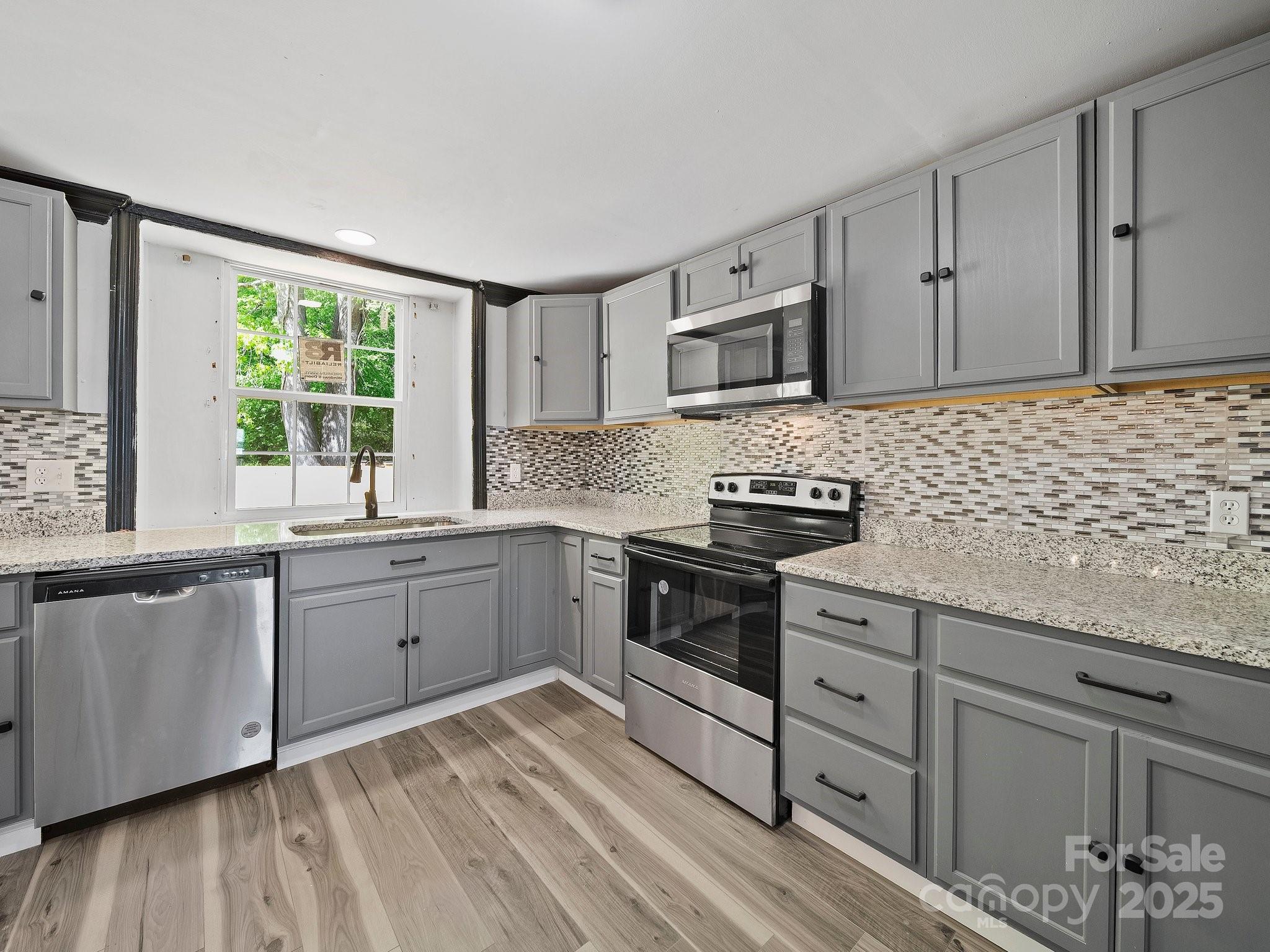 308 Miller Street, Unit 1 Jefferson, SC 29718 - Photo 13 of 44 a kitchen with granite countertop cabinets stainless steel appliances a sink and a window
