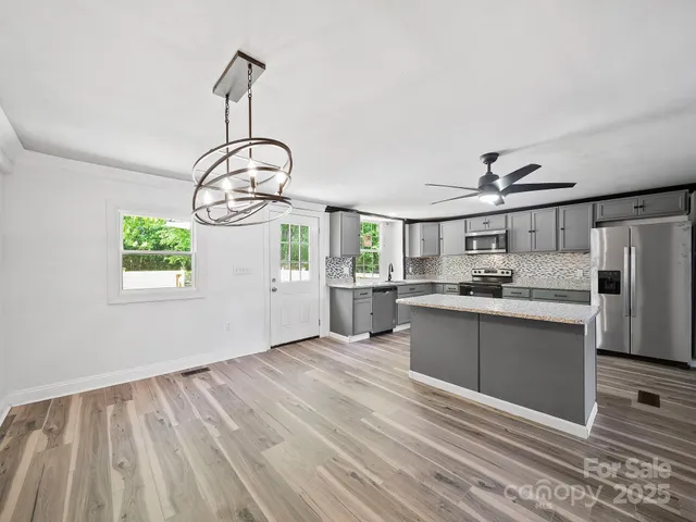 a kitchen with cabinets wooden floor and a view of kitchen