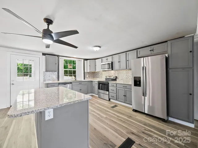 a kitchen with stainless steel appliances a refrigerator sink and stove