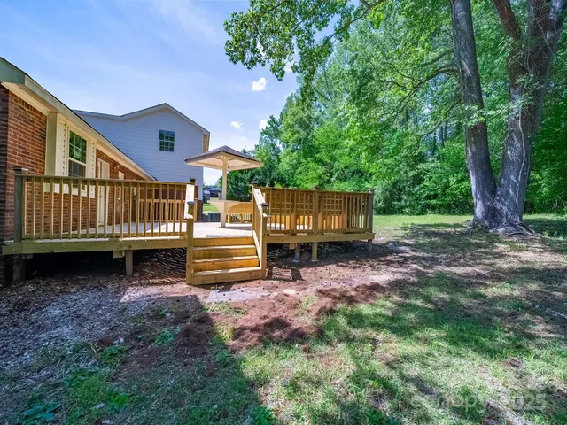 a view of a house with backyard and sitting area