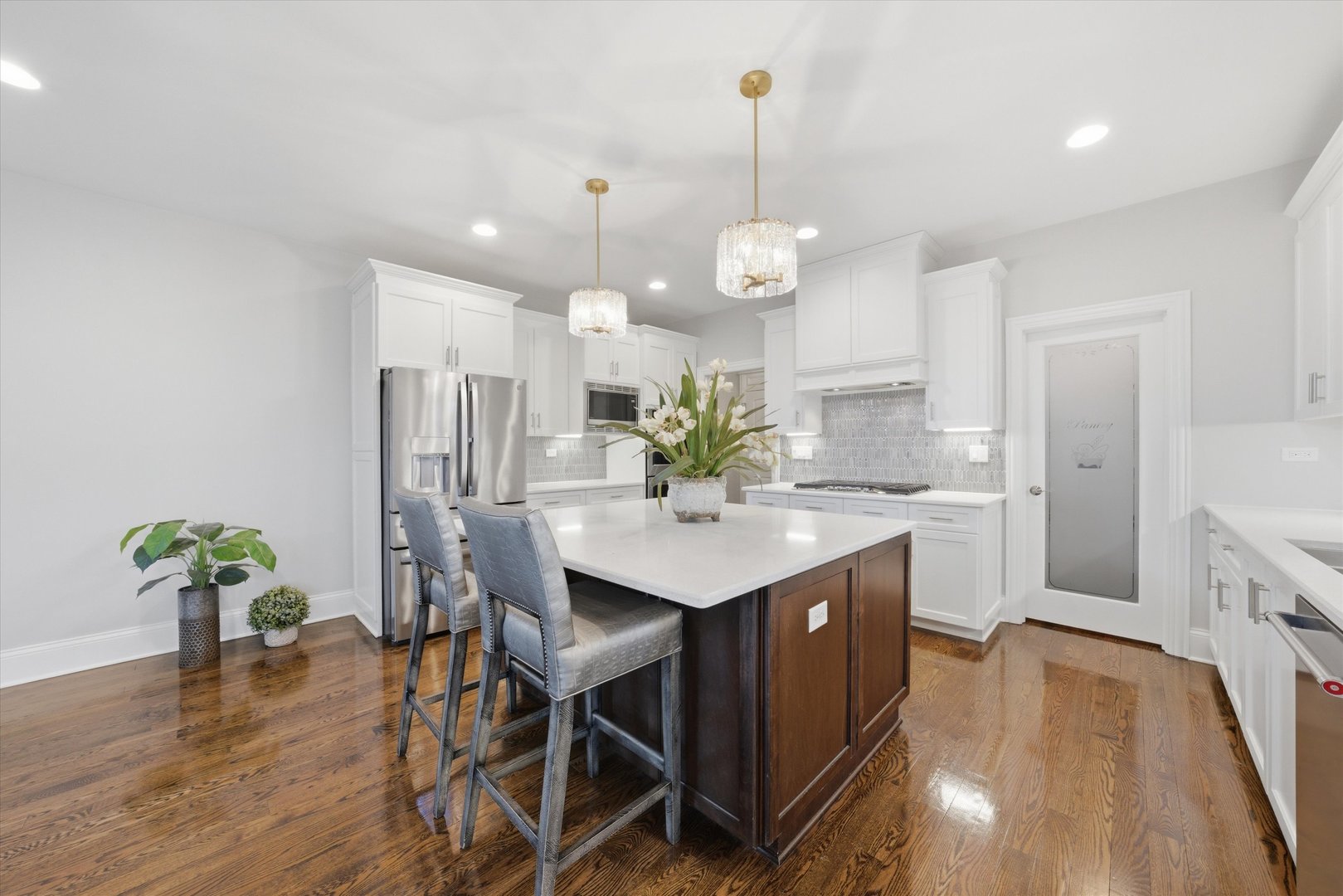 8613 High Stone Way Frankfort, IL 60423 - Photo 20 of 57 a kitchen with stainless steel appliances kitchen island a chandelier and wooden floor