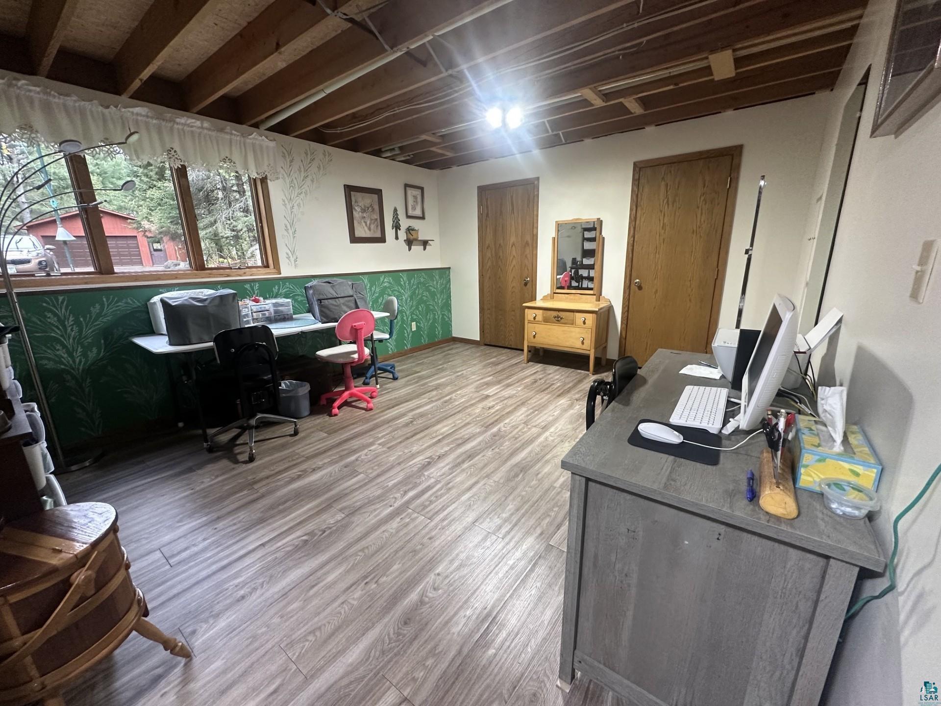 81 Hautaluoma Road Esko, MN 55733 - Photo 25 of 43 Spacious room featuring wood-finish flooring, exposed ceiling joists, and multiple windows