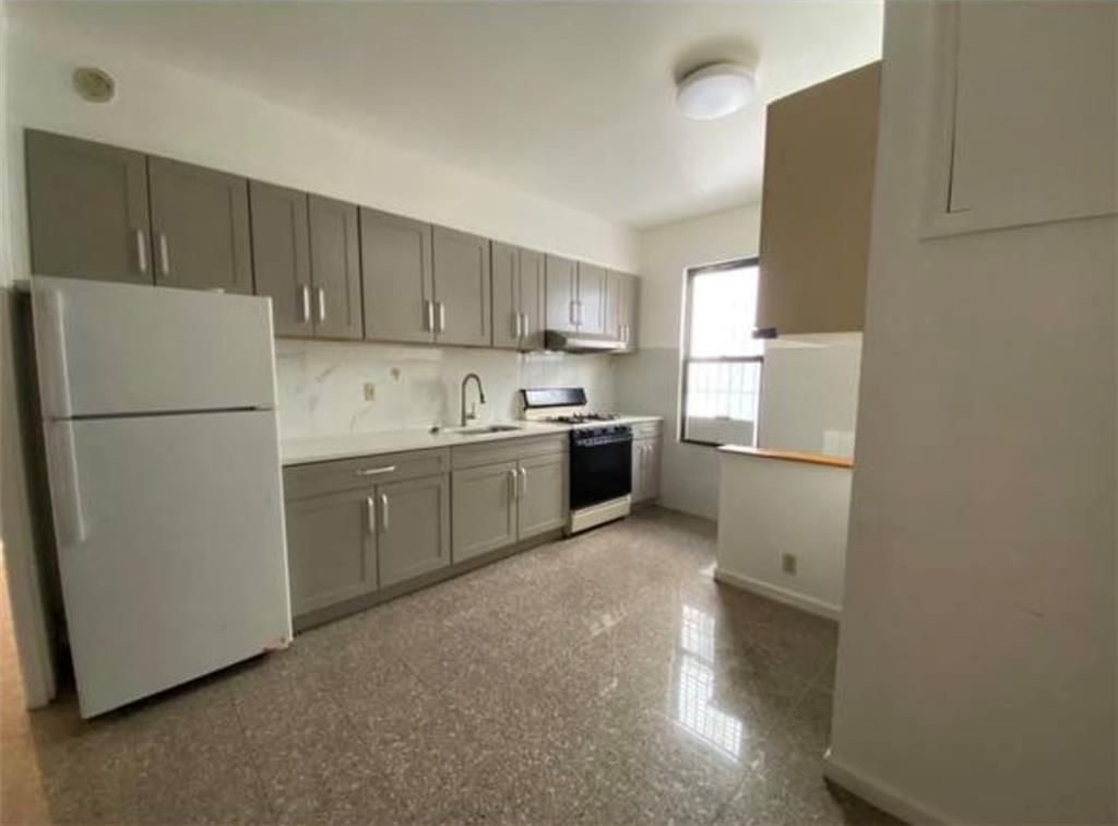 352 68th Street Brooklyn, NY 11220 - Photo 2 of 14 a kitchen with a sink a refrigerator and a stove top oven