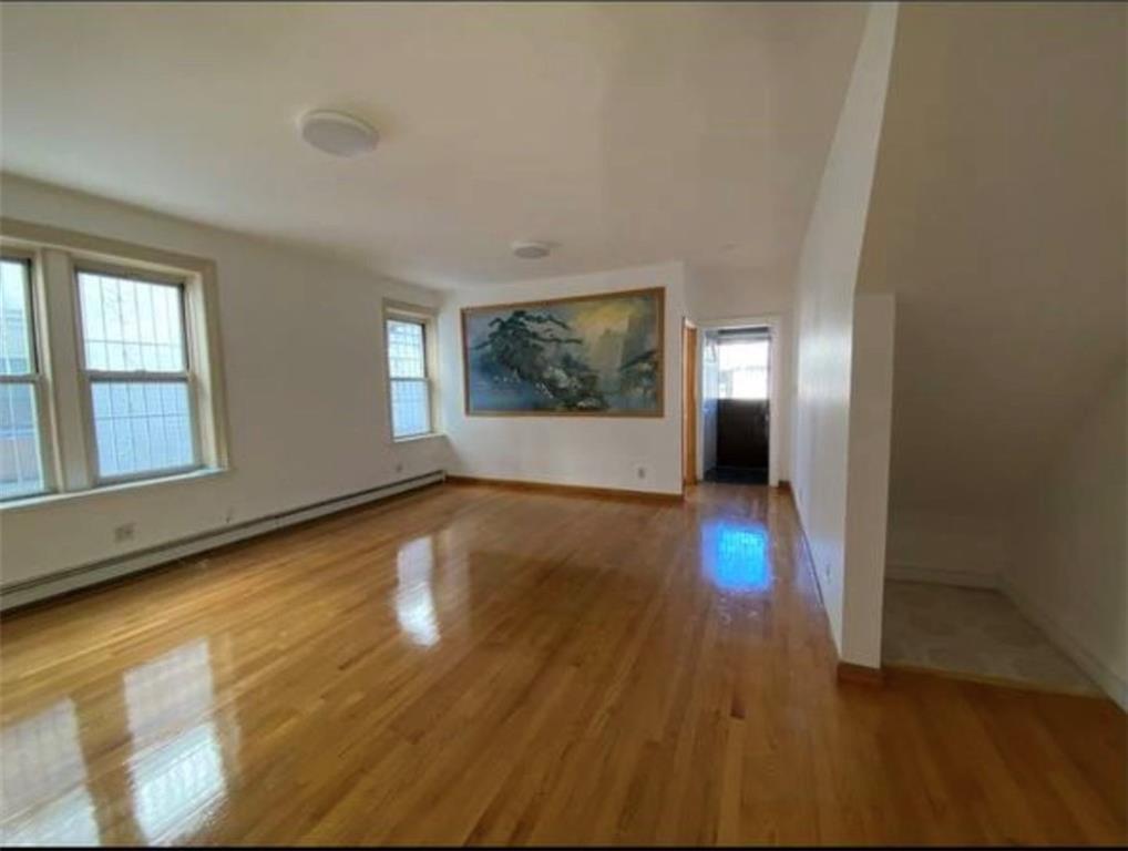 352 68th Street Brooklyn, NY 11220 - Photo 8 of 14 an empty room with wooden floor and windows