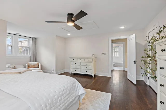 a spacious bedroom with a bed and wooden floor