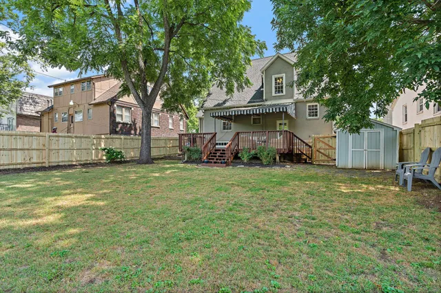 a view of a house with wooden stairs and a bench