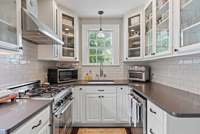 a kitchen with granite countertop a stove sink and cabinets