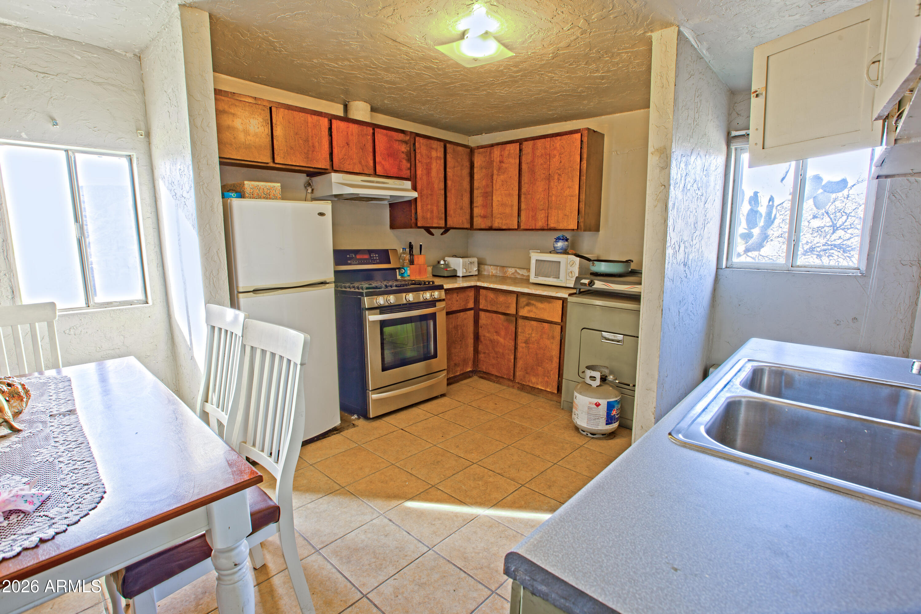 512 West Pinto Street Miami, AZ 85539 - Photo 19 of 27 a kitchen with stainless steel appliances granite countertop a sink a stove a refrigerator a washer dryer and a dining table
