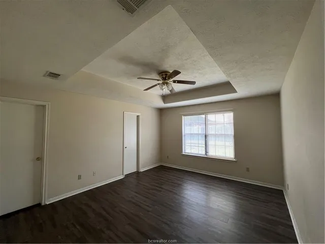a kitchen with a sink a stove cabinets and a wooden floor