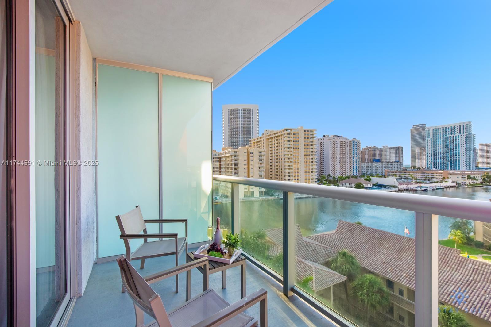 2602 East Hallandale Beach Boulevard, Unit R803 Hallandale Beach, FL 33009 - Photo 6 of 17 a balcony with a table and chairs