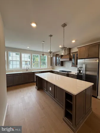 a large kitchen with kitchen island a large counter space appliances and a ceiling fan