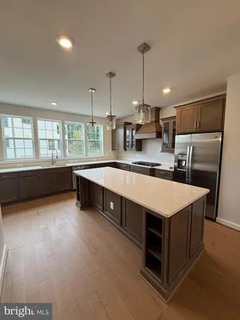 a kitchen with stainless steel appliances granite countertop a sink a stove and a refrigerator