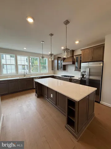 a kitchen with stainless steel appliances granite countertop a sink a stove and a refrigerator