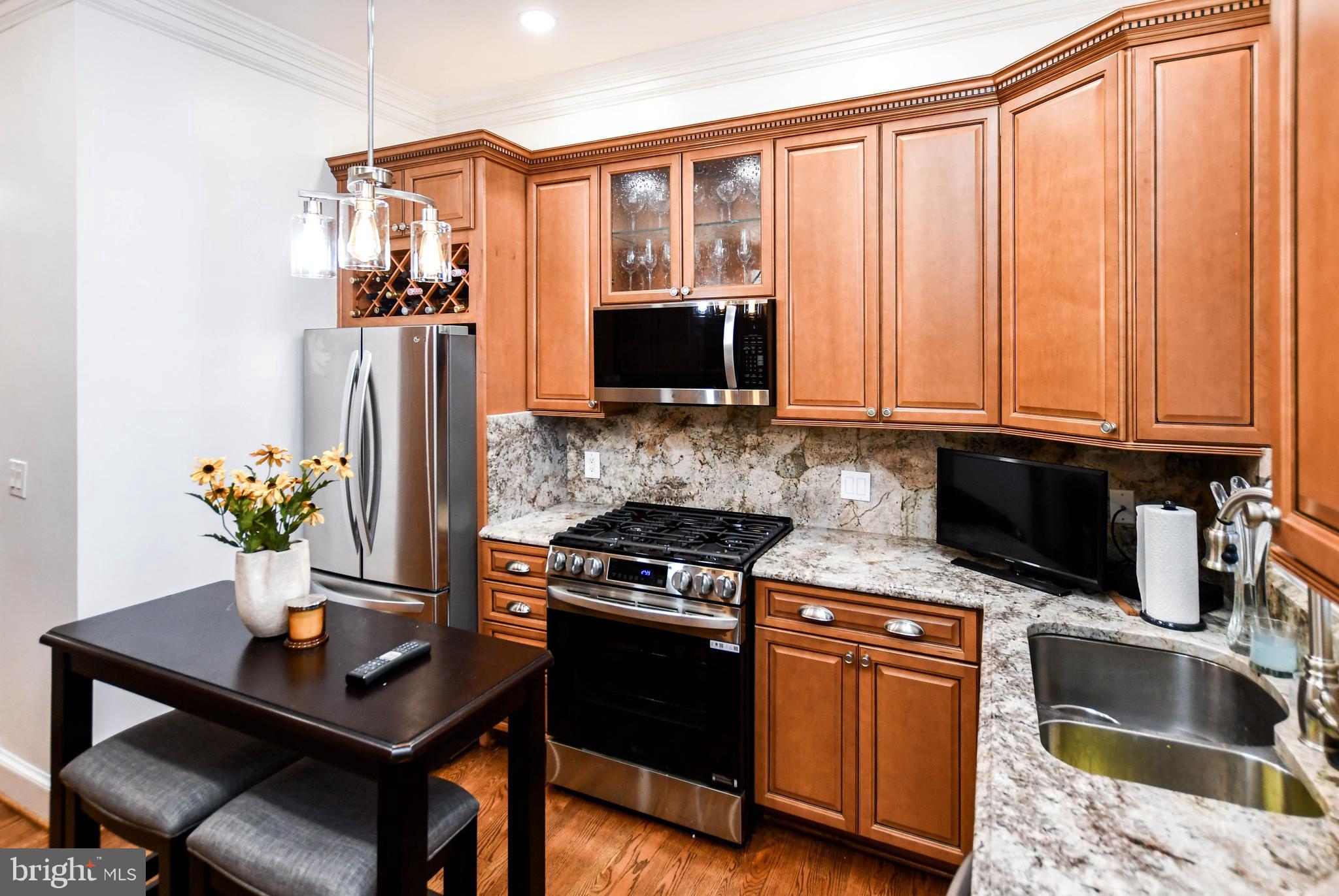 34 R Street Northeast Washington, DC 20002 - Photo 24 of 74 a kitchen with stainless steel appliances kitchen island granite countertop a refrigerator and a stove top oven