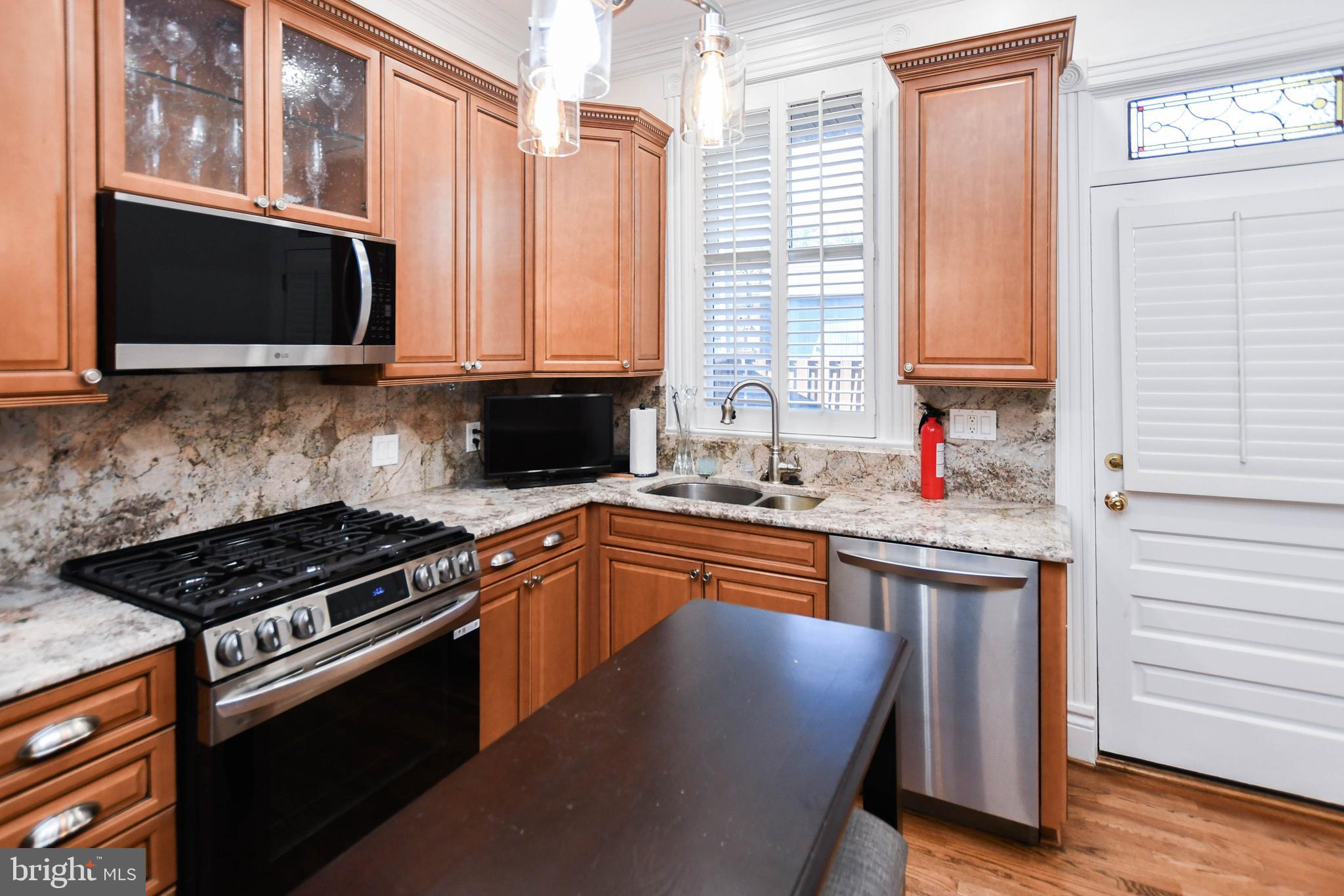 34 R Street Northeast Washington, DC 20002 - Photo 26 of 74 a kitchen with stainless steel appliances granite countertop a stove a sink and a microwave