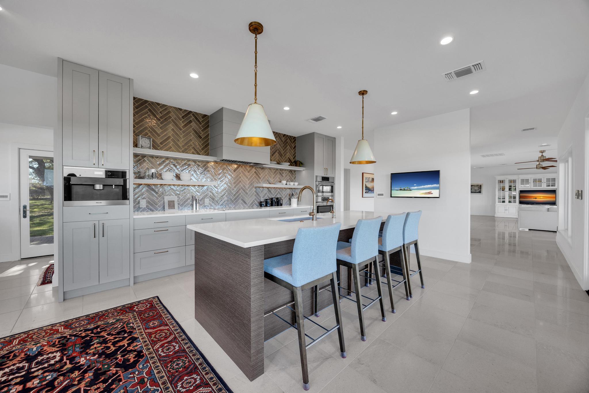 24710 Fossil Trail Spicewood, TX 78669 - Photo 11 of 40 a kitchen with stainless steel appliances kitchen island granite countertop a sink a stove a refrigerator and cabinets