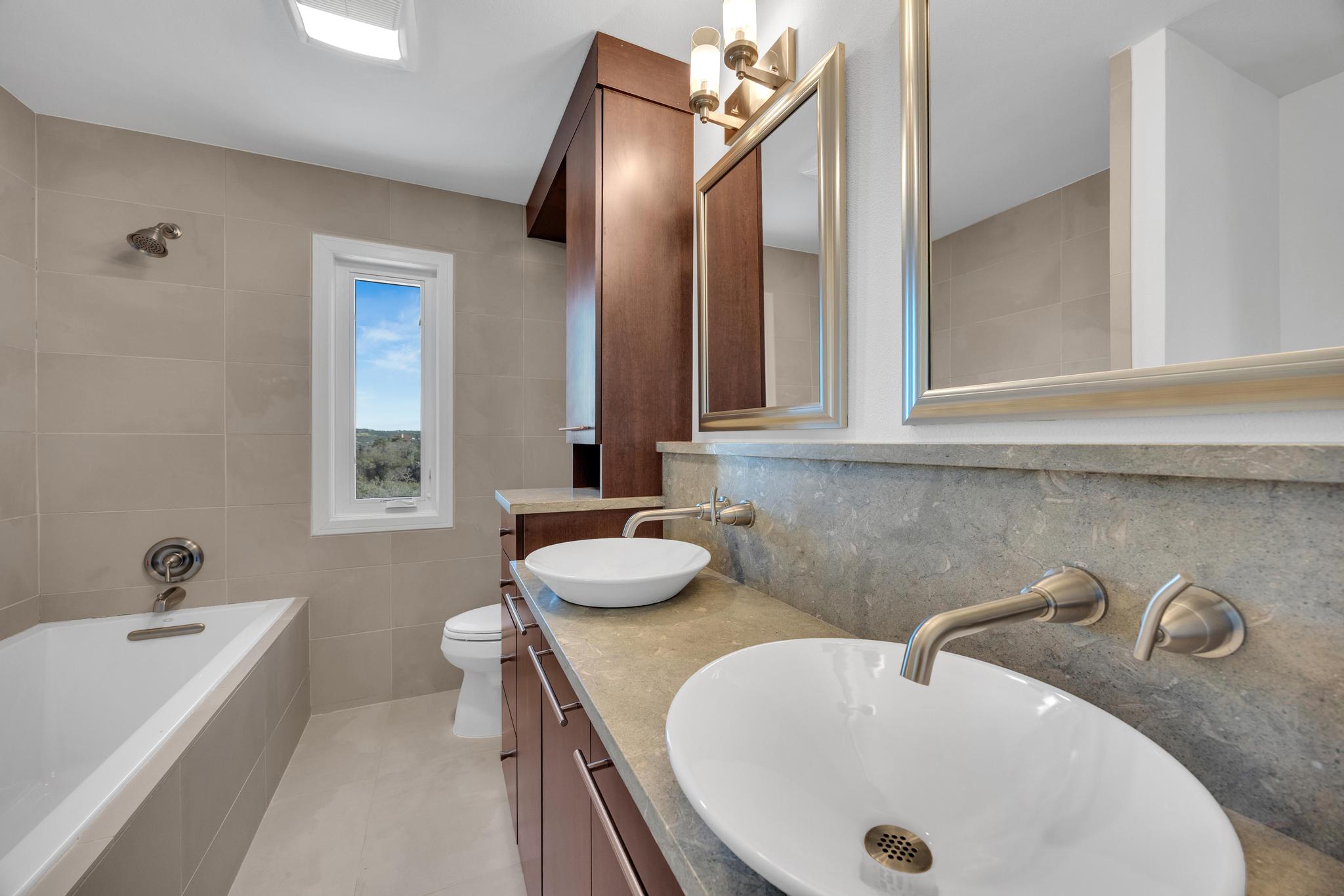 24710 Fossil Trail Spicewood, TX 78669 - Photo 20 of 40 a bathroom with a double vanity sink and a bathtub