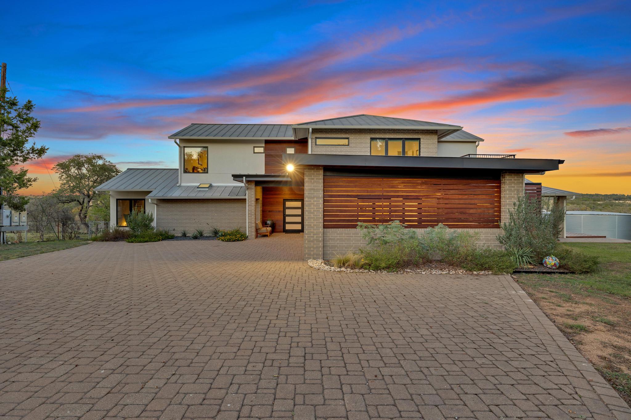 24710 Fossil Trail Spicewood, TX 78669 - Photo 2 of 40 a front view of a house with a yard and garage