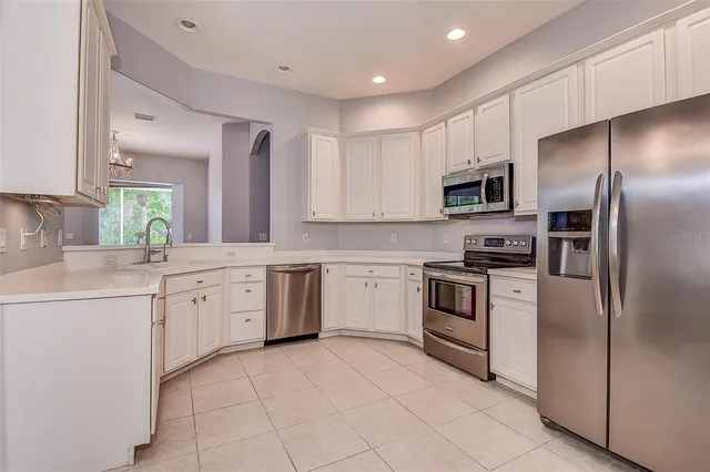 a kitchen with cabinets stainless steel appliances and a counter top space