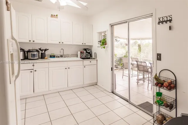a kitchen with white cabinets and window