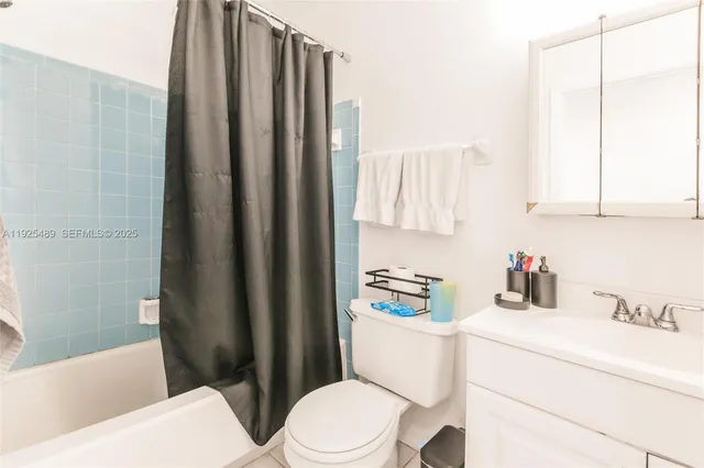 a bathroom with a sink a toilet and shower curtain