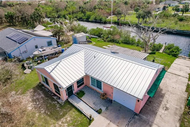 an aerial view of a house with a yard patio and lake view in back